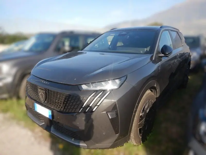 Peugeot 5008 gris en 3/4 avant droit, mettant en valeur sa calandre distinctive et ses phares LED effilés.