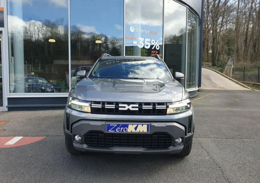 Vue avant d’un Dacia Dokker Van gris schiste avec calandre noire et feux LED, stationné devant une vitrine.