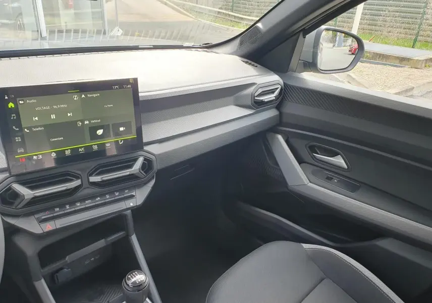 Intérieur côté passager du Dacia Dokker Van gris schiste, avec tableau de bord moderne et écran tactile central.