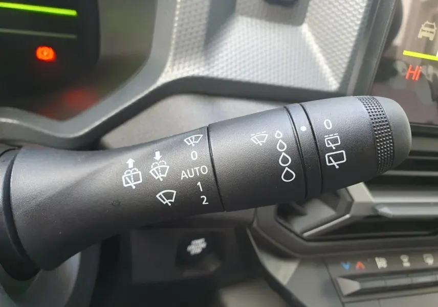 Gros plan sur la commande des essuie-glaces du tableau de bord intérieur du Dacia Dokker Van gris schiste 2026.