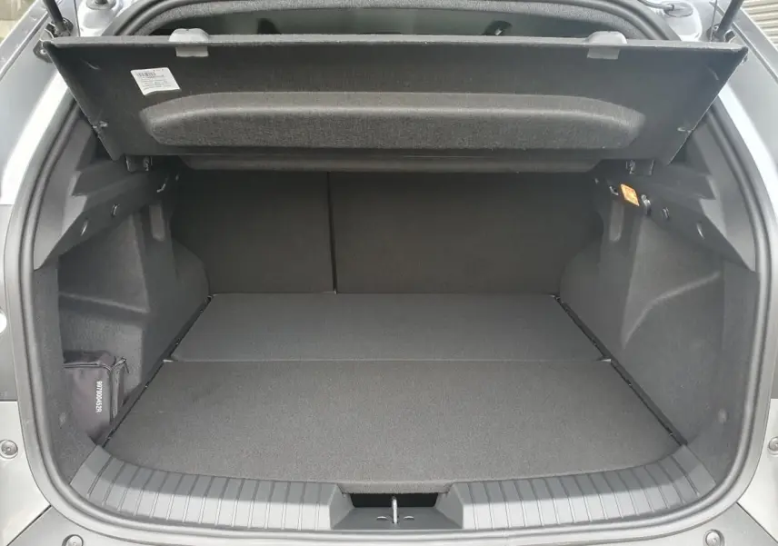 Coffre ouvert vu de l'arrière du Dacia Dokker Van gris schiste, montrant un espace de chargement plat et spacieux.