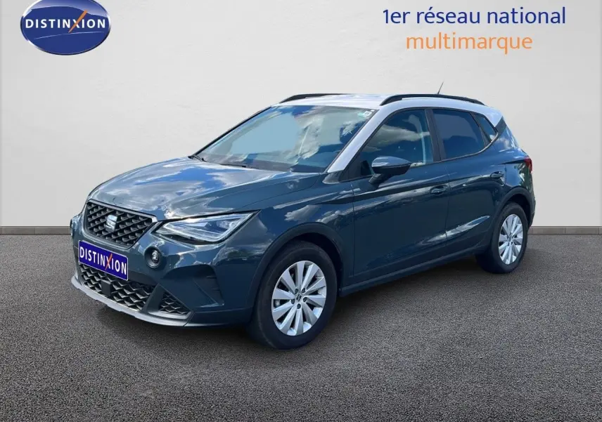 SEAT Arona bleu Fjord avec toit blanc, vue 3/4 avant droit, mettant en valeur ses lignes modernes et ses jantes argentées.