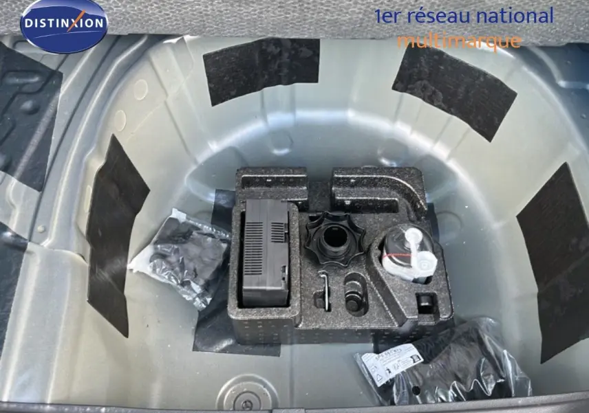 Coffre ouvert montrant la roue de secours et les outils de bord du SEAT Arona bleu Fjord avec toit blanc, vue de dessus.