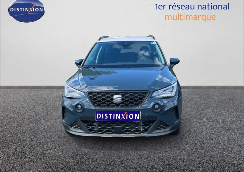 Vue frontale d'un SEAT Arona bleu Fjord avec toit blanc, mettant en valeur sa calandre et ses phares LED distinctifs.