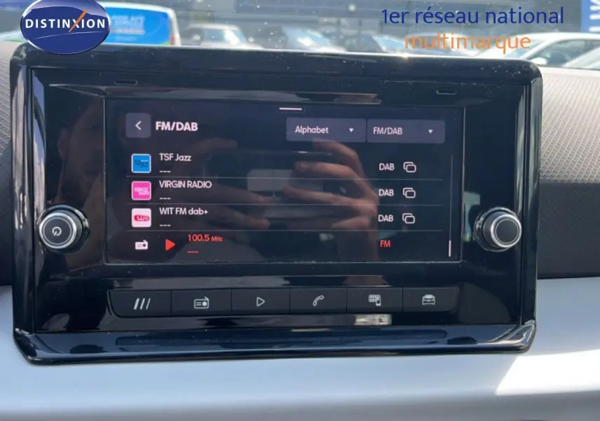 Écran tactile central du tableau de bord du SEAT Arona 2025 affichant les options radio FM/DAB en intérieur clair.