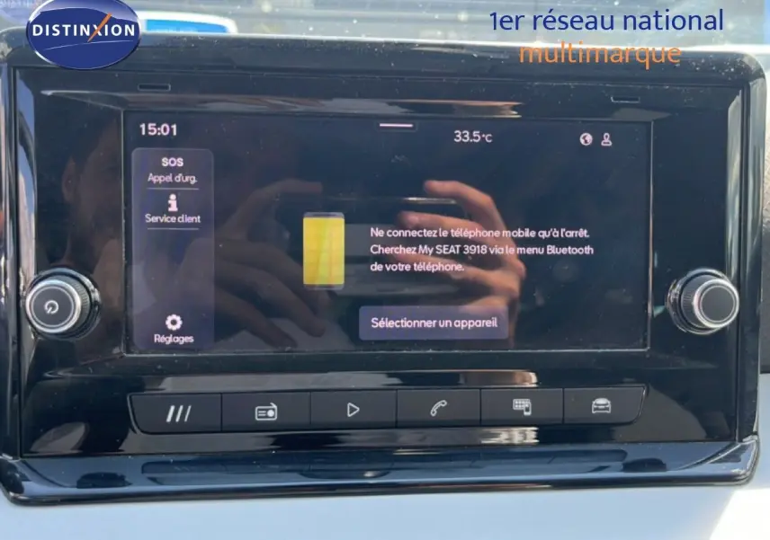 Écran tactile central du tableau de bord du SEAT Arona 2025, affichant le menu Bluetooth avec reflet des mains.