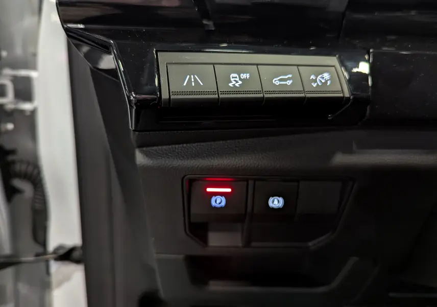 Gros plan sur les commandes de sécurité et assistance du tableau de bord du Renault Austral blanc nacré 2023.