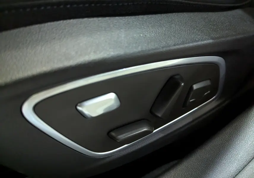 Commandes électriques des réglages de siège en gros plan sur une Renault Austral E-Tech blanc nacré, intérieur noir.