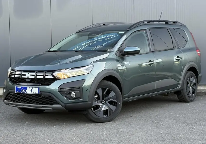 Vue 3/4 avant droit du Dacia Jogger 2024 Vert Cèdre avec barres de toit et jantes noires distinctives.