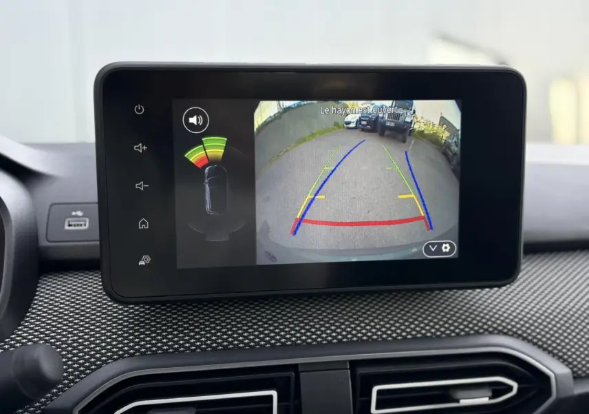 Écran tactile intérieur du Dacia Jogger affichant la caméra de recul avec guidage coloré et capteurs de proximité.