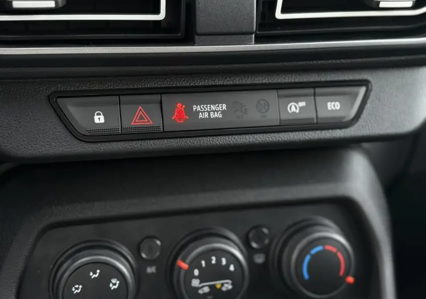 Gros plan sur la console centrale du Dacia Jogger 2024, montrant les commandes de climatisation et les boutons d'alerte et d'économie d'énergie.