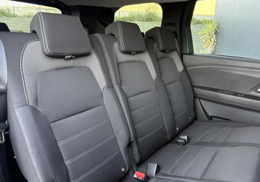 Banquette arrière en tissu gris foncé du Dacia Jogger 2024, vue côté droit avec trois appuie-têtes et ceinture de sécurité.