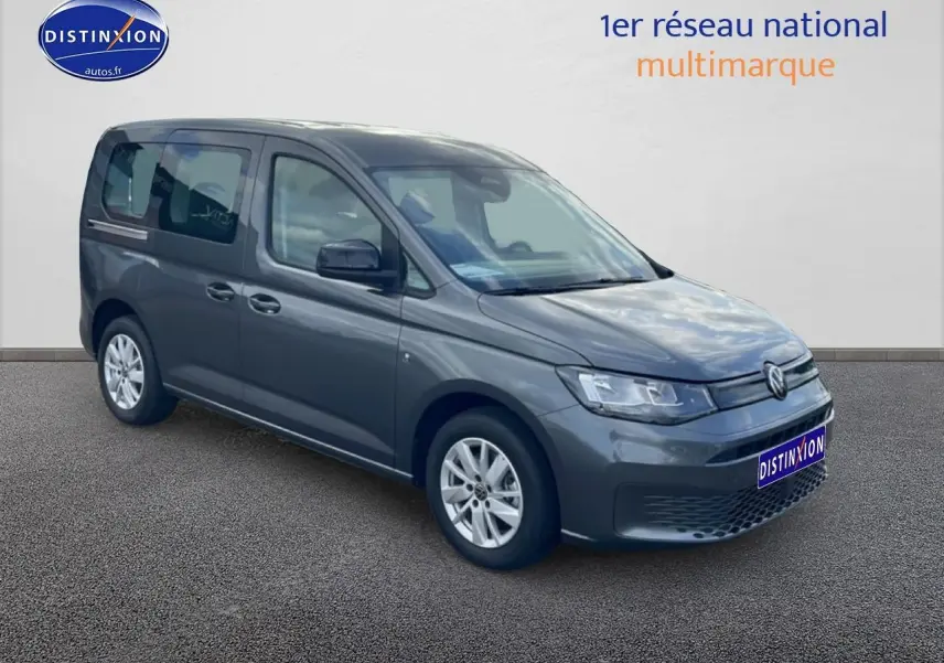 Volkswagen Caddy gris indien en 3/4 avant droit, avec jantes alliage et vitres teintées arrière.