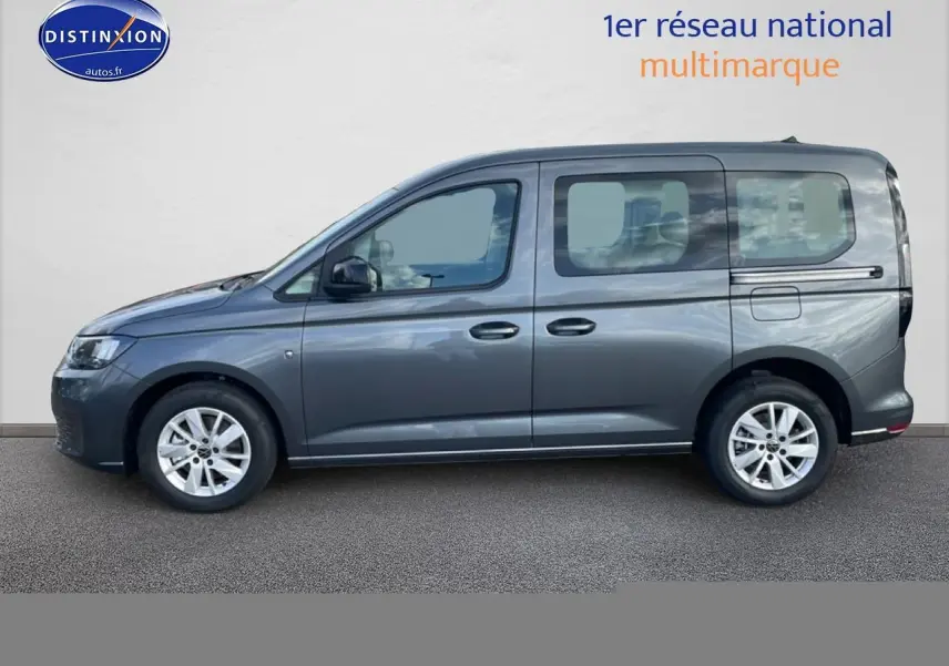 Vue de profil côté gauche d'un Volkswagen Caddy gris indien 2025 avec vitres teintées et jantes alliage.