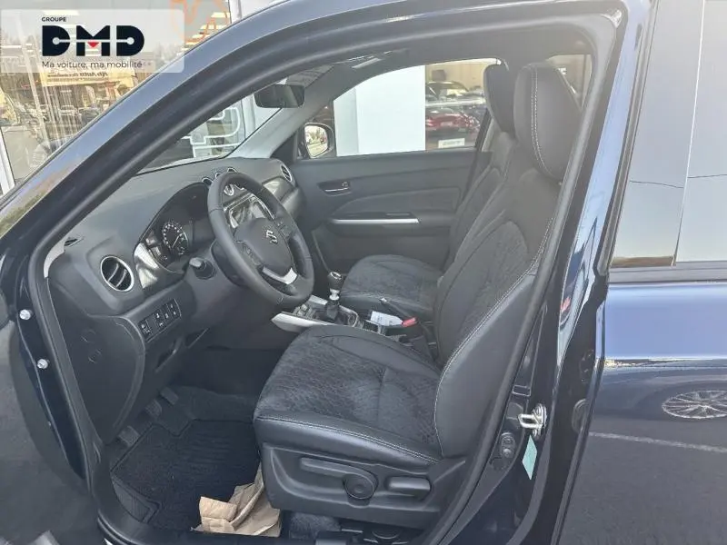 Intérieur côté conducteur du Suzuki Vitara bleu So'Color, sièges cuir et suédine noirs avec coutures blanches.