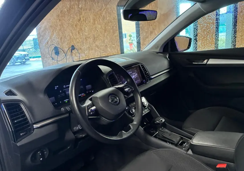 Intérieur noir du Skoda Karoq 2023 vu côté conducteur, tableau de bord digital et console centrale avec boîte auto DSG7.