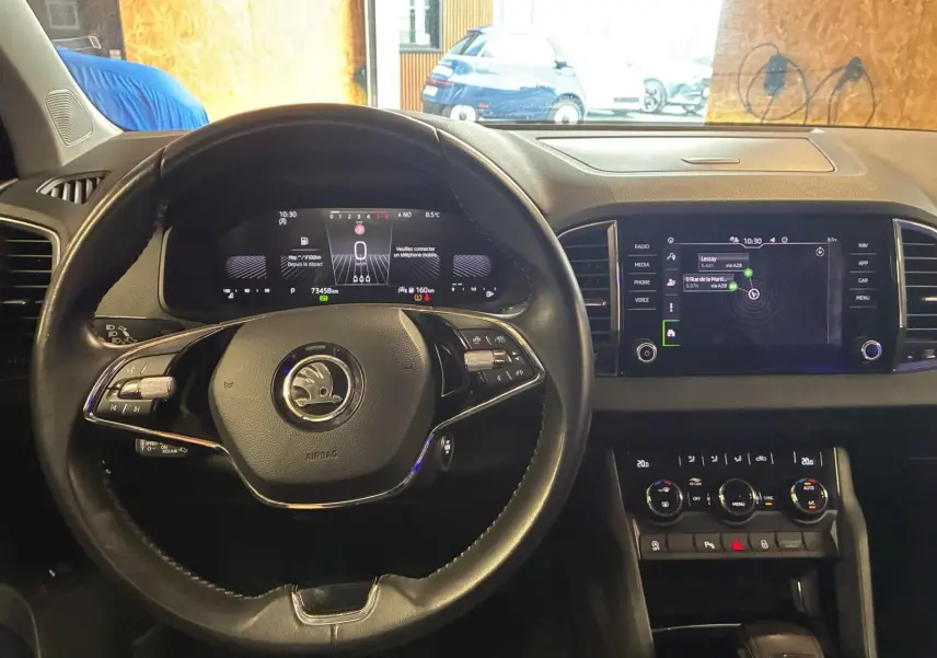 Vue intérieure du tableau de bord et volant noir du Skoda Karoq 2.0 TDI 115 DSG7 Business avec écran tactile et commandes au volant.
