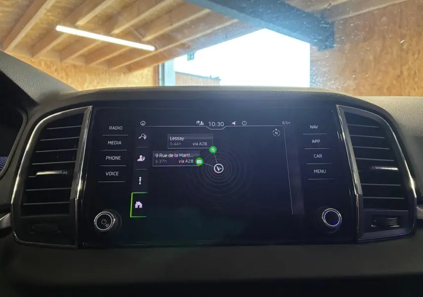 Écran central tactile du Skoda Karoq 2023 noir, affichant le GPS avec menu latéral et commandes autour.