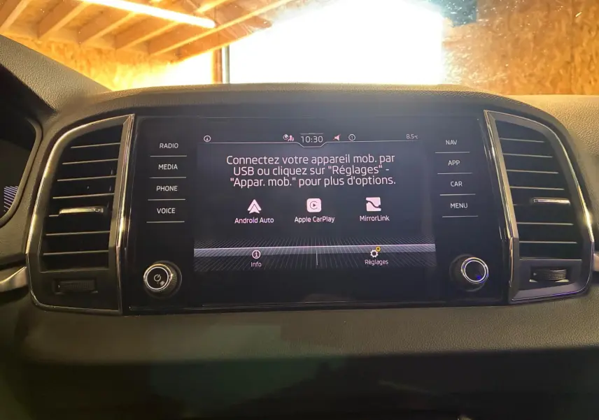 Écran central tactile du Skoda Karoq 2023 noir, affichant les options Android Auto, Apple CarPlay et MirrorLink.