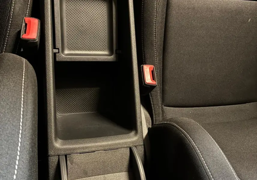 Vue plongeante sur le rangement central noir et les sièges en tissu noir de la Skoda Karoq 2023 version Business.