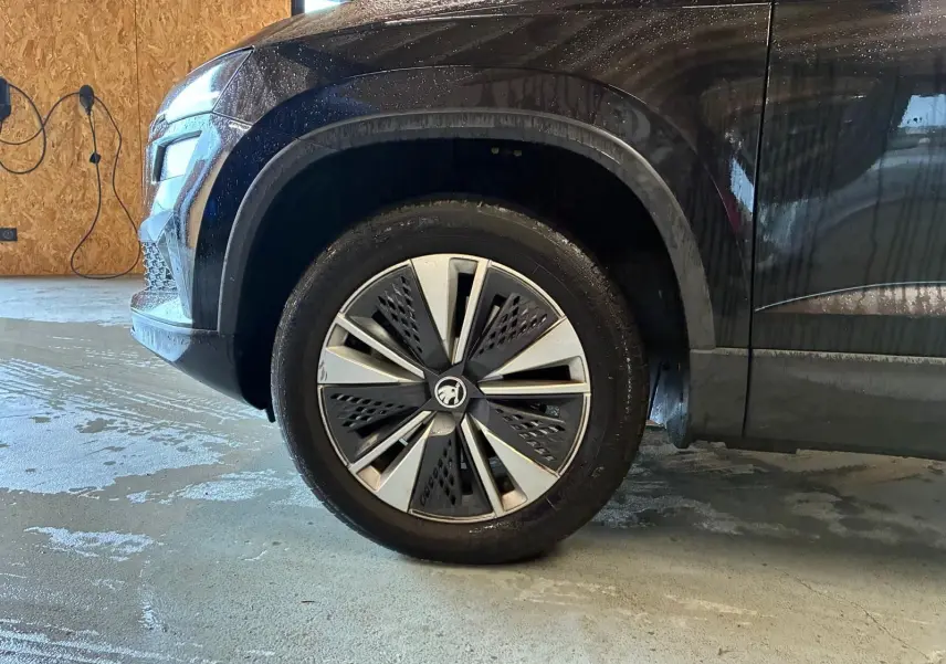 Gros plan sur la roue avant gauche d'un Skoda Karoq noir 2023, mettant en valeur la jante au design moderne.