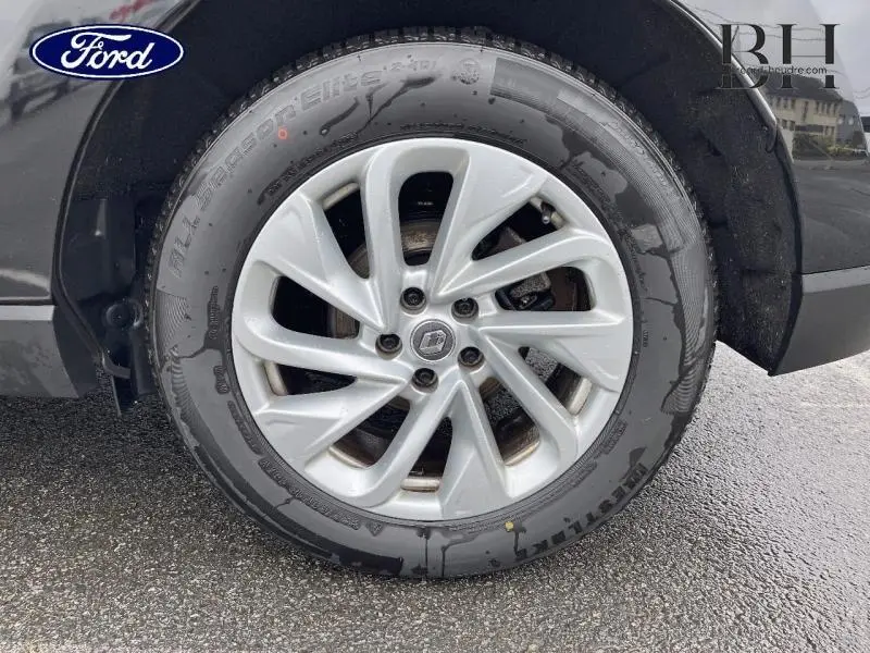 Gros plan sur la roue avant droite avec jante alu argentée du Renault Espace noir étoilé 2017.