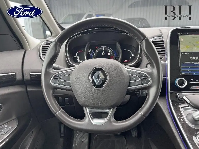 Vue rapprochée du volant cuir noir étoilé d’un Renault Espace 2017 avec tableau de bord numérique et écran tactile.