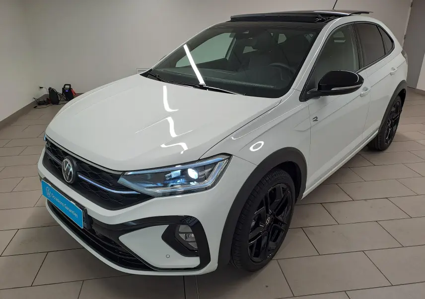Volkswagen Taigo blanc pur avec toit noir en 3/4 avant droit, jantes noires et phares LED allumés.