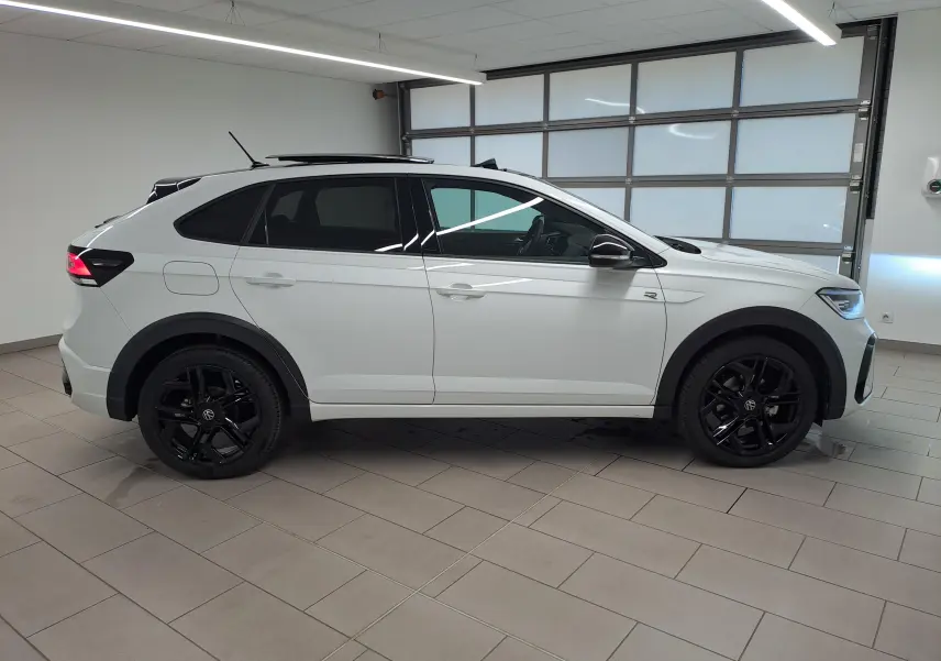 Vue de profil côté droit du Volkswagen Taigo blanc pur avec toit noir et jantes noires en alliage.
