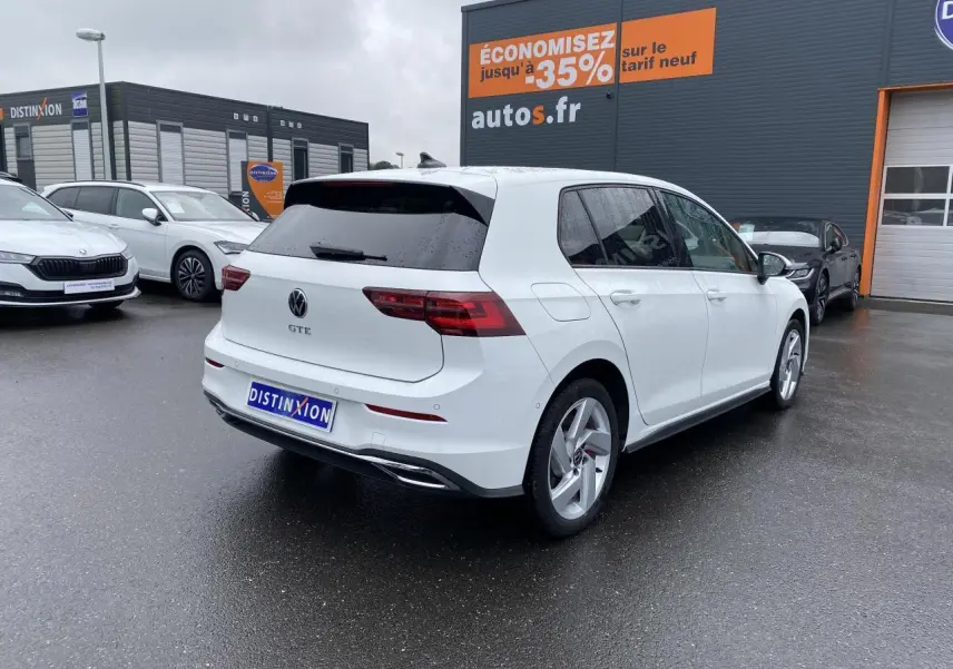 Volkswagen Golf 1.4 eHybrid blanche vue 3/4 arrière droit, avec logo GTE et jantes alliage sport.