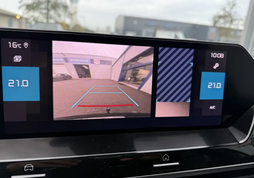 Affichage de la caméra de recul sur l'écran central d'une Citroën C4 noire avec attelage, montrant l'arrière du véhicule et la zone de stationnement.