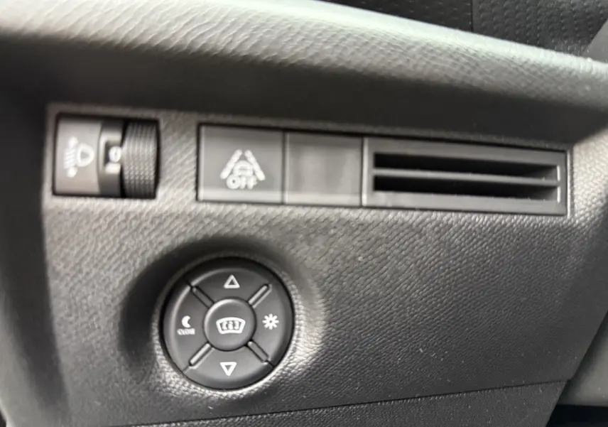 Détail du tableau de bord noir de la Citroën C4 2022 avec commandes d'éclairage et ventilation latérale.