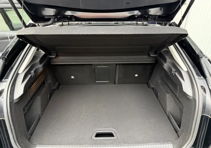 Coffre ouvert vu de l'arrière d'une Citroën C4 noire 2022, montrant un espace de chargement propre et spacieux.
