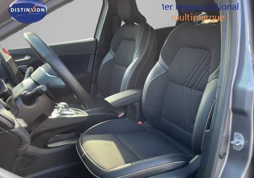 Vue intérieure côté gauche montrant les sièges avant en tissu noir avec surpiqûres, portière ouverte d'une Renault Symbioz gris cassiopée.