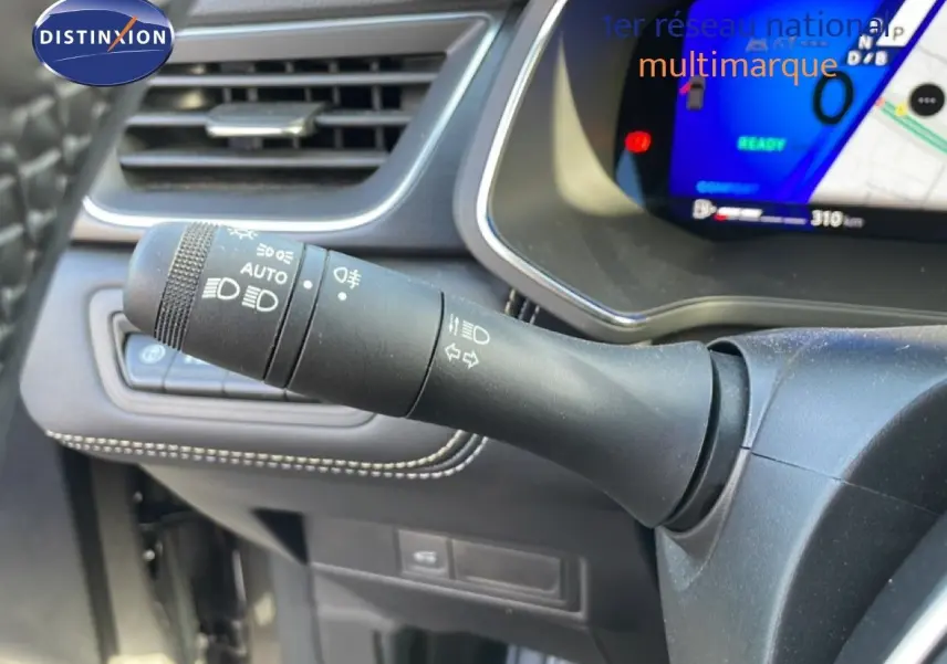 Gros plan sur la commande des phares à gauche du volant dans l’habitacle gris cassiopée métal du Renault Symbioz 2025.