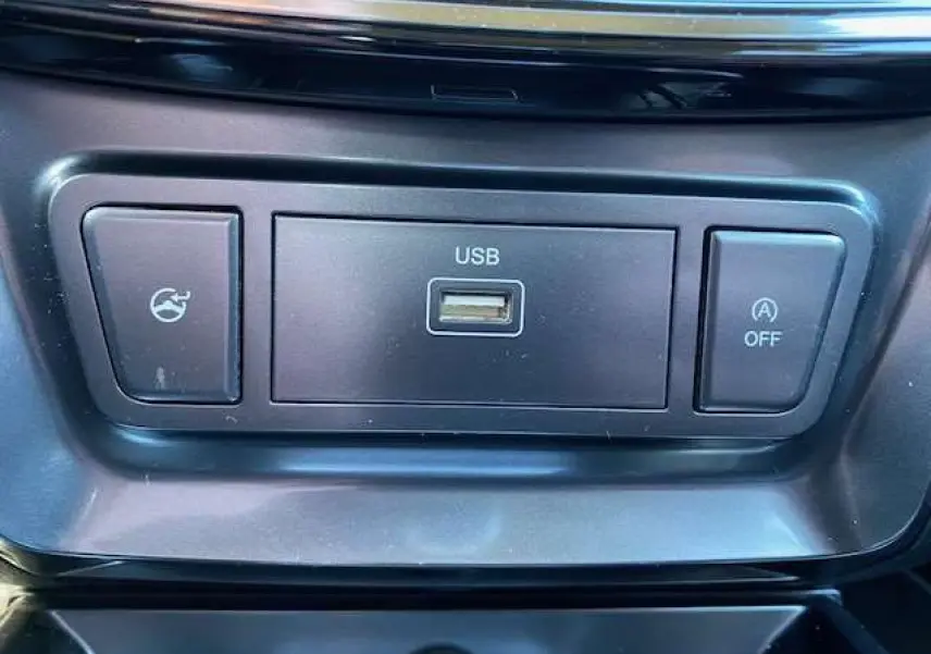 Gros plan sur la prise USB et les boutons de commande noirs dans l'habitacle du SsangYong Tivoli gris foncé 2021.