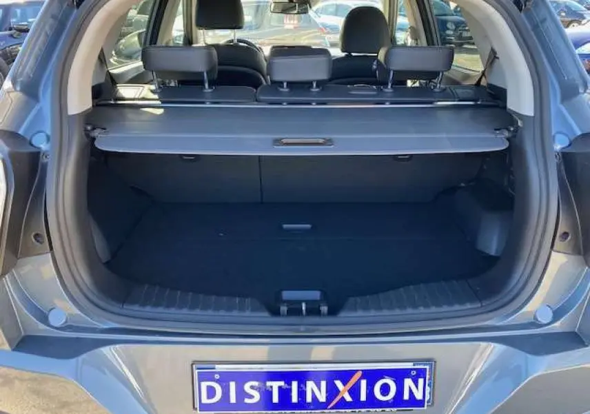 Coffre ouvert d'un SsangYong Tivoli gris foncé 2021, vue arrière montrant la plage arrière et les appuie-têtes noirs.