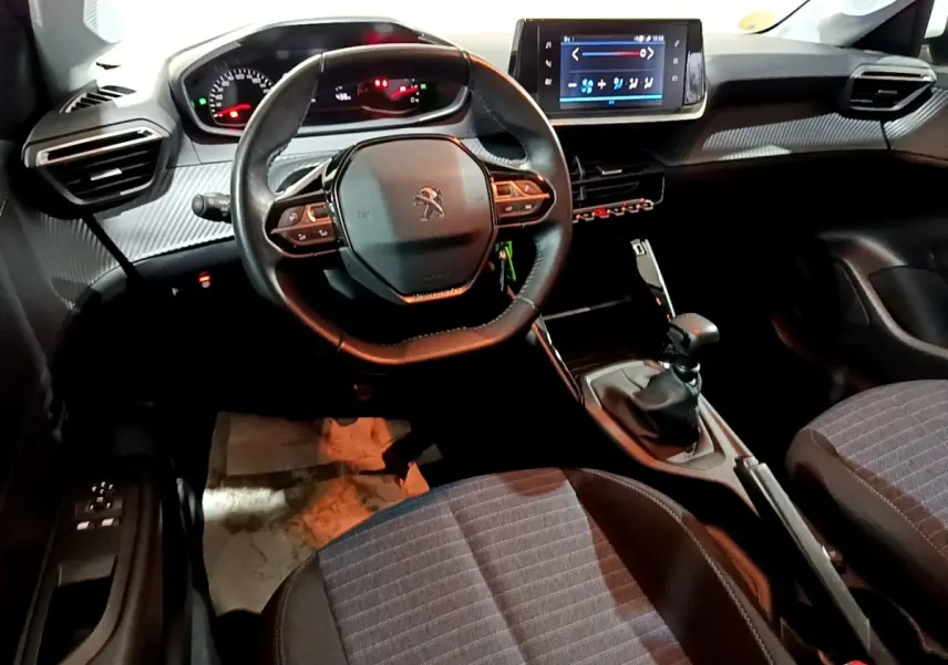 Vue intérieure avant de la Peugeot 208 1.5 BlueHDi 100 S&S Premium, volant multifonction et écran tactile central visible.