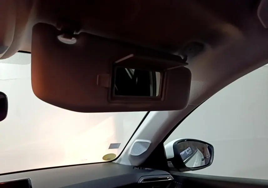 Vue intérieure côté gauche du pare-soleil avec miroir ouvert dans une Peugeot 208 blanche de 2021.