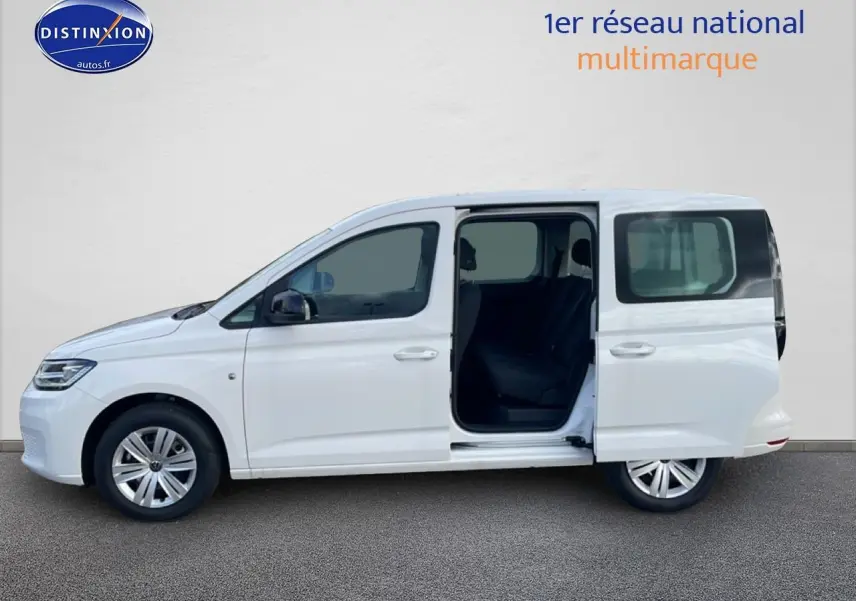 Vue latérale droite d’un Volkswagen Caddy blanc 2025 avec porte coulissante arrière ouverte, intérieur sombre visible.
