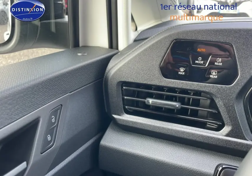 Détail de la console centrale et de la porte côté conducteur du Volkswagen Caddy blanc, avec commandes de climatisation et verrouillage.