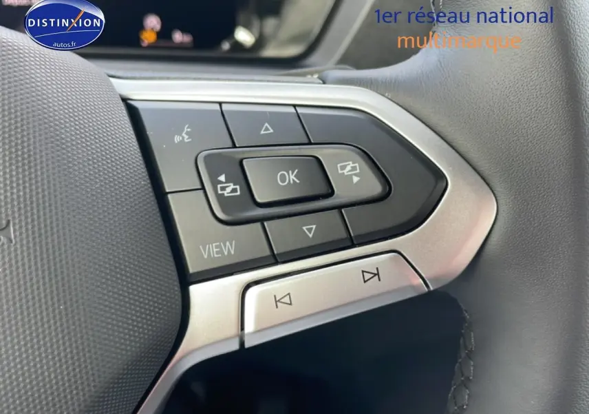 Gros plan sur les commandes gauche du volant cuir multifonction du Volkswagen Caddy blanc 2025.