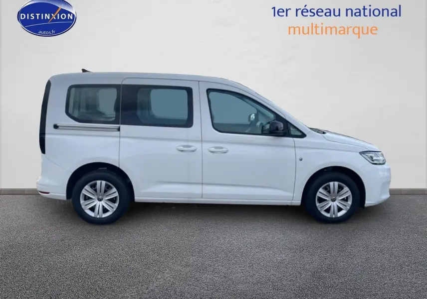 Vue de profil côté gauche d'un Volkswagen Caddy blanc 2025 avec vitres teintées et barres de toit visibles.