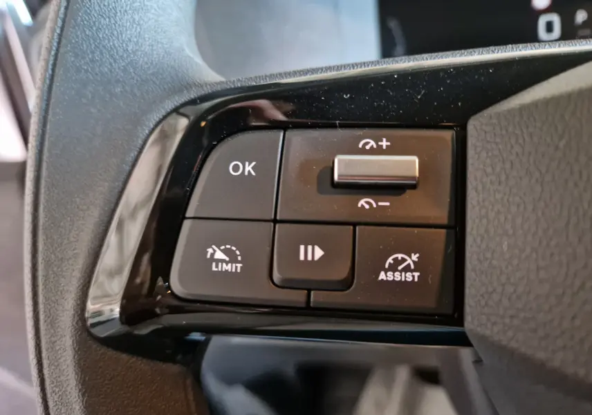 Gros plan sur les commandes du volant du Peugeot Expert Cabine Approfondie gris titane, mettant en valeur les boutons de limitation et assistance de vitesse.