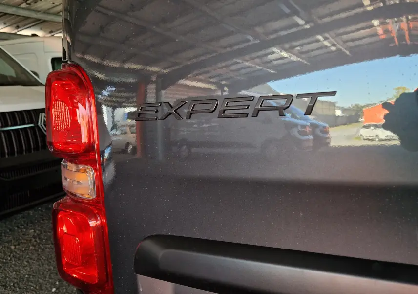 Gros plan sur l'arrière gauche gris titane du Peugeot Expert avec le logo "EXPERT" et le feu arrière rouge visible.