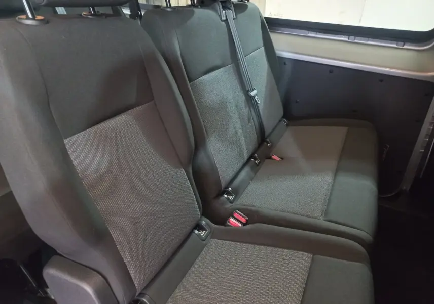 Vue intérieure côté droit sur la troisième rangée de sièges gris foncé du Peugeot Traveller 2021, banquette 3 places rabattable.
