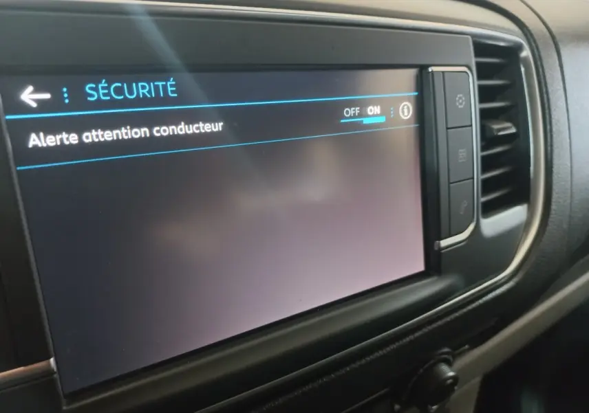 Écran tactile central du tableau de bord du Peugeot Traveller 2021 affichant le menu sécurité avec alerte attention conducteur activée.