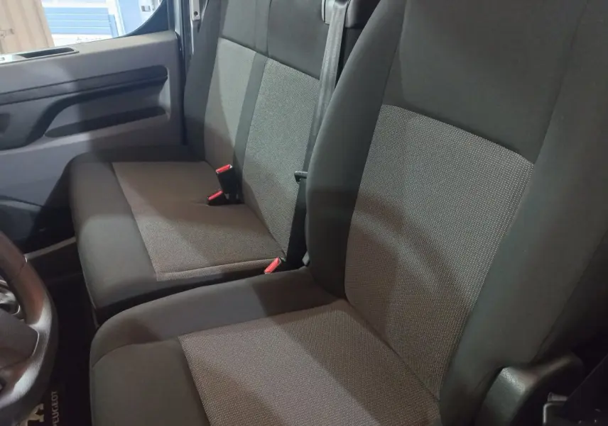 Vue intérieure rapprochée des sièges avant gris foncé du Peugeot Traveller 2021, côté conducteur et passager.