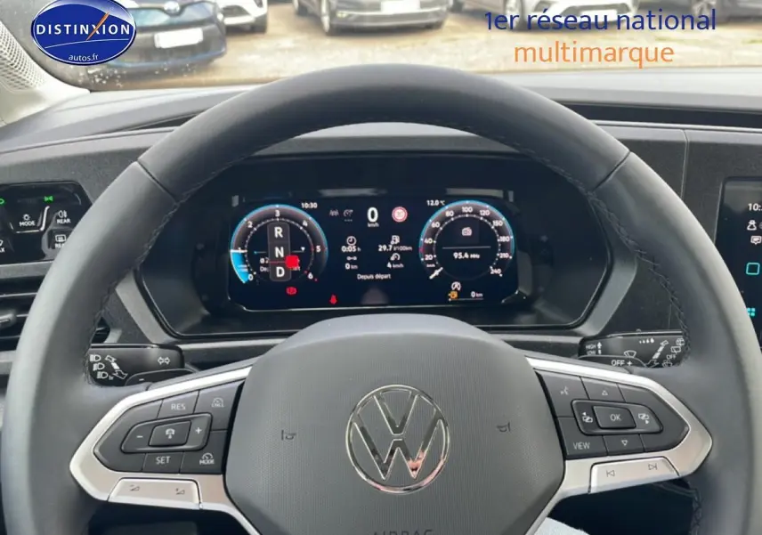 Vue intérieure centrée sur le volant cuir multifonction d’un Volkswagen Caddy gris indien avec tableau de bord numérique.