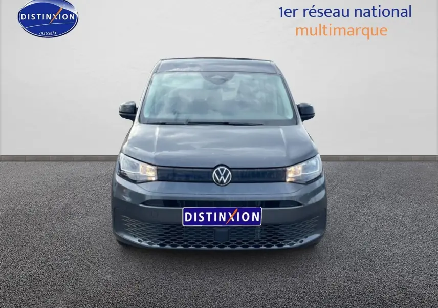 Vue de face du Volkswagen Caddy gris indien 2025 avec calandre noire et logo VW centré.